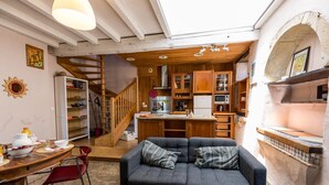 Un espace de vie compact comprenant une cuisine, un coin repas et un escalier menant à un niveau supérieur.
