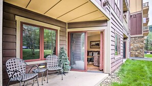A covered patio with two metal chairs and a small Christmas tree. - Cozy Red Hawk Lodge Condo: Walk to River Run! (Keystone)