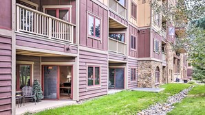 A multi-story building with balconies, a covered porch, and a stone facade. - Cozy Red Hawk Lodge Condo: Walk to River Run! (Keystone)