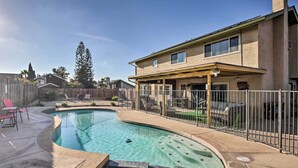 A backyard with a swimming pool, a covered patio, and a fenced area. - 'breeze By the Pool' Chula Vista Home w/ Game Room (Chula Vista)