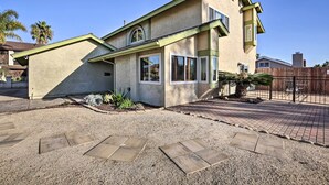 A two-story house with a beige exterior, a green roof, and a gravel driveway. - 'breeze By the Pool' Chula Vista Home w/ Game Room (Chula Vista)