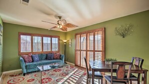A dining area with a wooden table and chairs, a blue sofa, and a patterned rug. - 'breeze By the Pool' Chula Vista Home w/ Game Room (Chula Vista)
