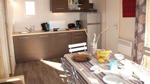 A compact kitchen with a microwave, refrigerator, and a small window.