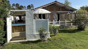 Une maison à deux étages dotée d’un patio couvert, d’une cour clôturée et d’un petit jardin.