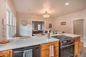 A modern kitchen with a central island, built-in oven, and stainless steel appliances. - Charming Downtown Home w/ Updated Interior! (Oklahoma City)