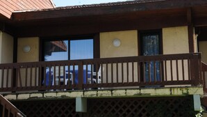 A building with a balcony, a window, and a door.