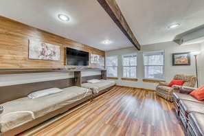 A room with a bunk bed, a sofa, and a TV mounted on the wall. - Ruidoso Condo w/ Hot Tub: Long Walk to Midtown! (Ruidoso)