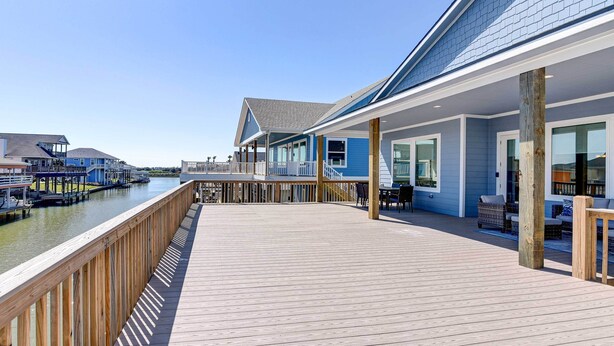 A wooden deck with a view of a water body and buildings in the background.