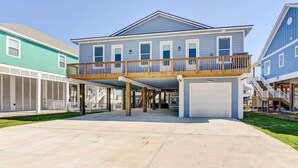 A two-story house with a covered patio, a garage, and a small deck.