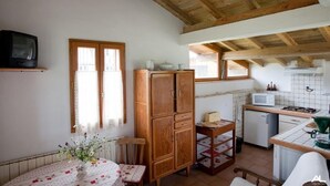 Eine Küche mit Holzschränken, einer Mikrowelle und einem kleinen Kühlschrank.
