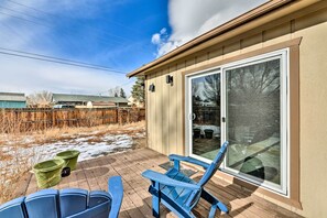 A patio with blue chairs, a sliding glass door, and a wooden deck. - Pet-friendly Home Near Downtown Buena Vista! (Buena Vista)