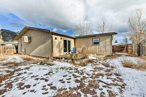 A two-story house with a garage, a covered porch, and a yard with snow patches. - Pet-friendly Home Near Downtown Buena Vista! (Buena Vista)