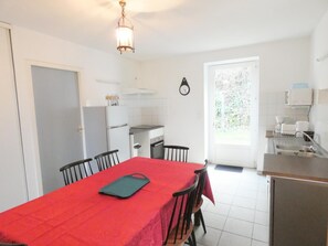 A compact kitchen with a dining area, a refrigerator, a stove, and a sink. - Le Pressoir - Orist - Gîte (ORIST)