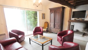 Un soggiorno con divani in pelle, un tavolino in vetro, un mobile in legno e un camino.