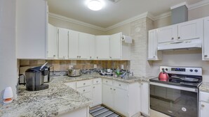 A kitchen with white cabinets, a stainless steel stove, and a coffee maker. - Cozy Oklahoma City Home w/ Deck & Gas Grill! (Oklahoma City)