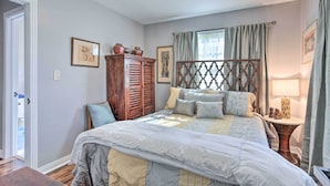 A bedroom with a large bed, wooden wardrobe, and a bedside table with a lamp.