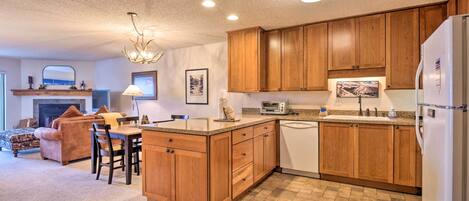 A modern kitchen with wooden cabinets, a built-in island, and a white refrigerator.