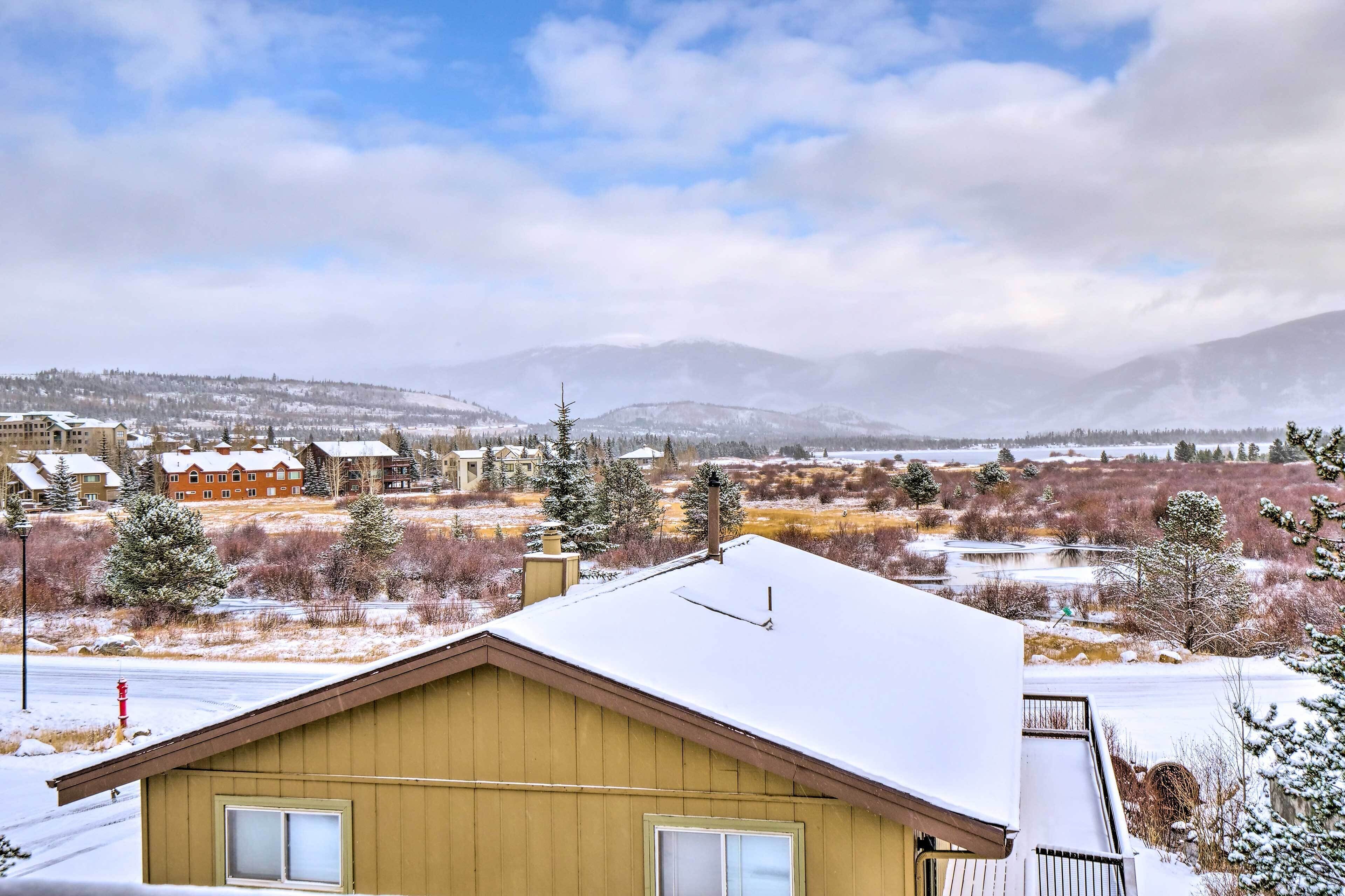 A residential area with houses and a view of snow-covered mountains.