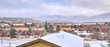 A residential area with houses and a view of snow-covered mountains.