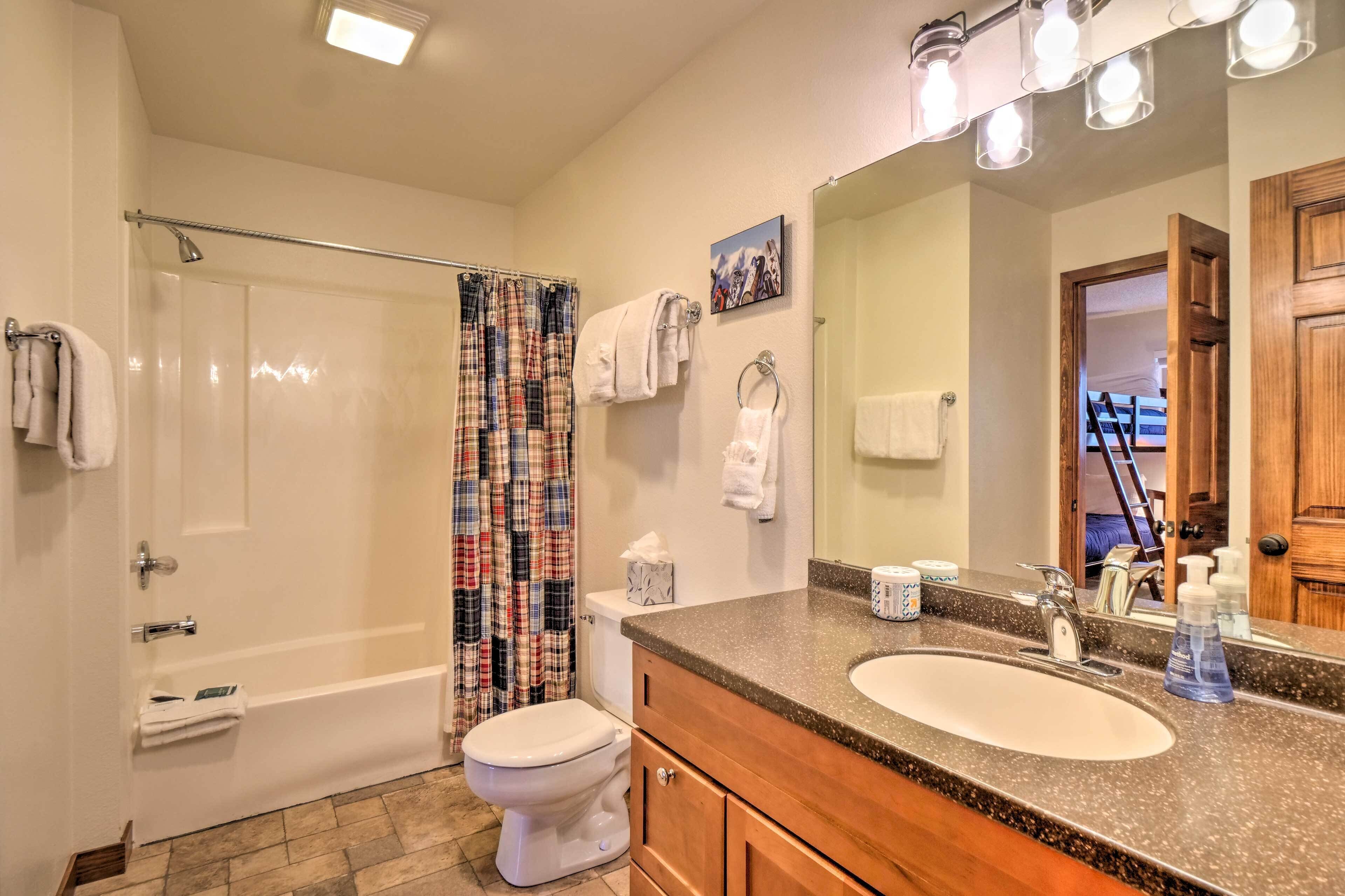 Une salle de bain équipée d’une douche, de toilettes, d’un lavabo et d’un grand miroir.