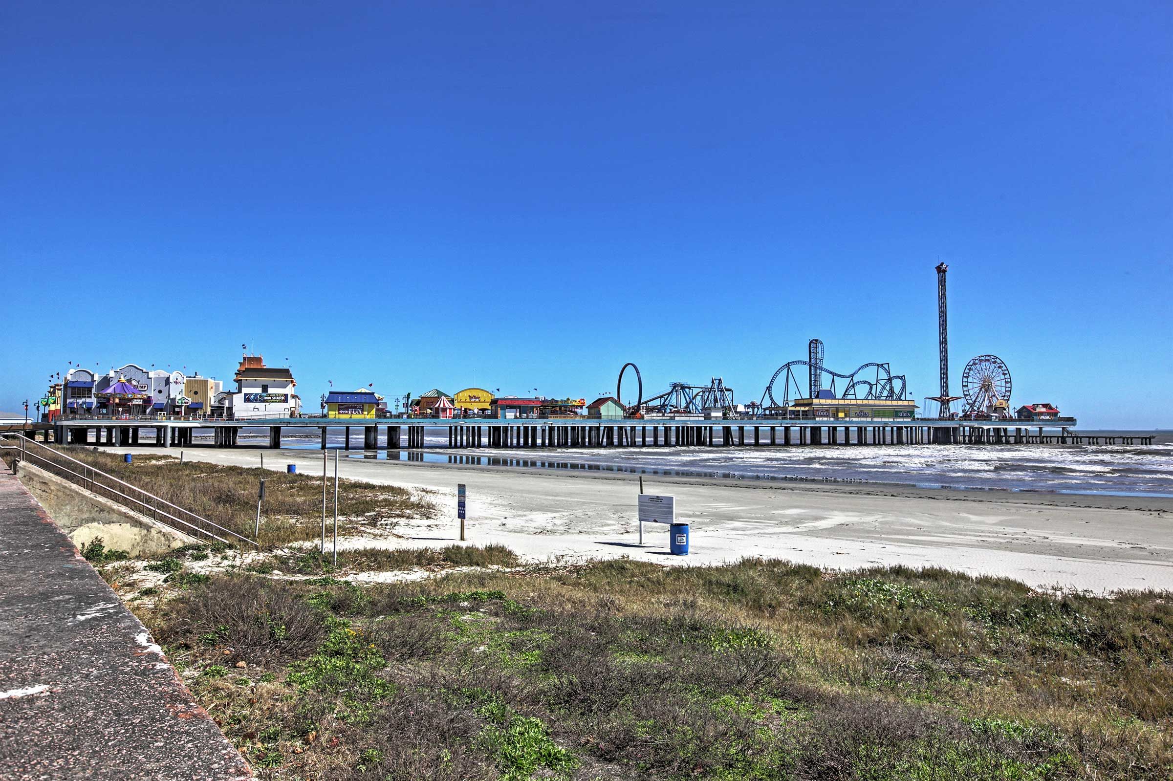 A pier with amusement rides and a Ferris wheel, extending into the water.