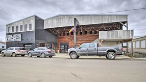 A building with a modern design, featuring a large garage door and a signboard. - Charming Mcminnville Home - Walk to Wineries! (McMinnville)