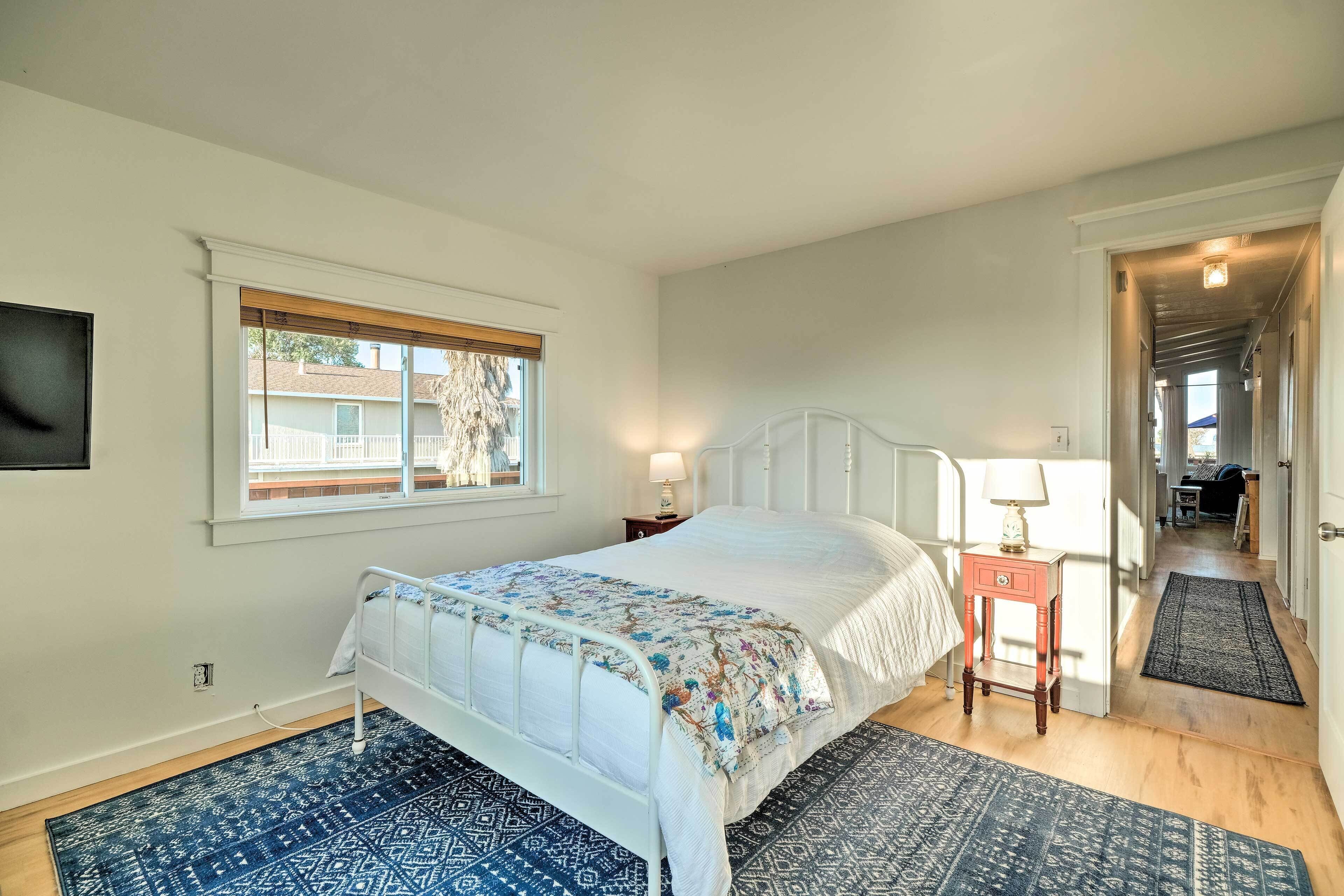 Une chambre à coucher avec un lit, une fenêtre, une table de chevet et une lampe de chevet.