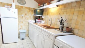 A compact kitchen with white cabinets, a built-in oven, a sink, and a microwave. - Le Tastet - Saint LON LES Mines (SAINT LON LES MINES)