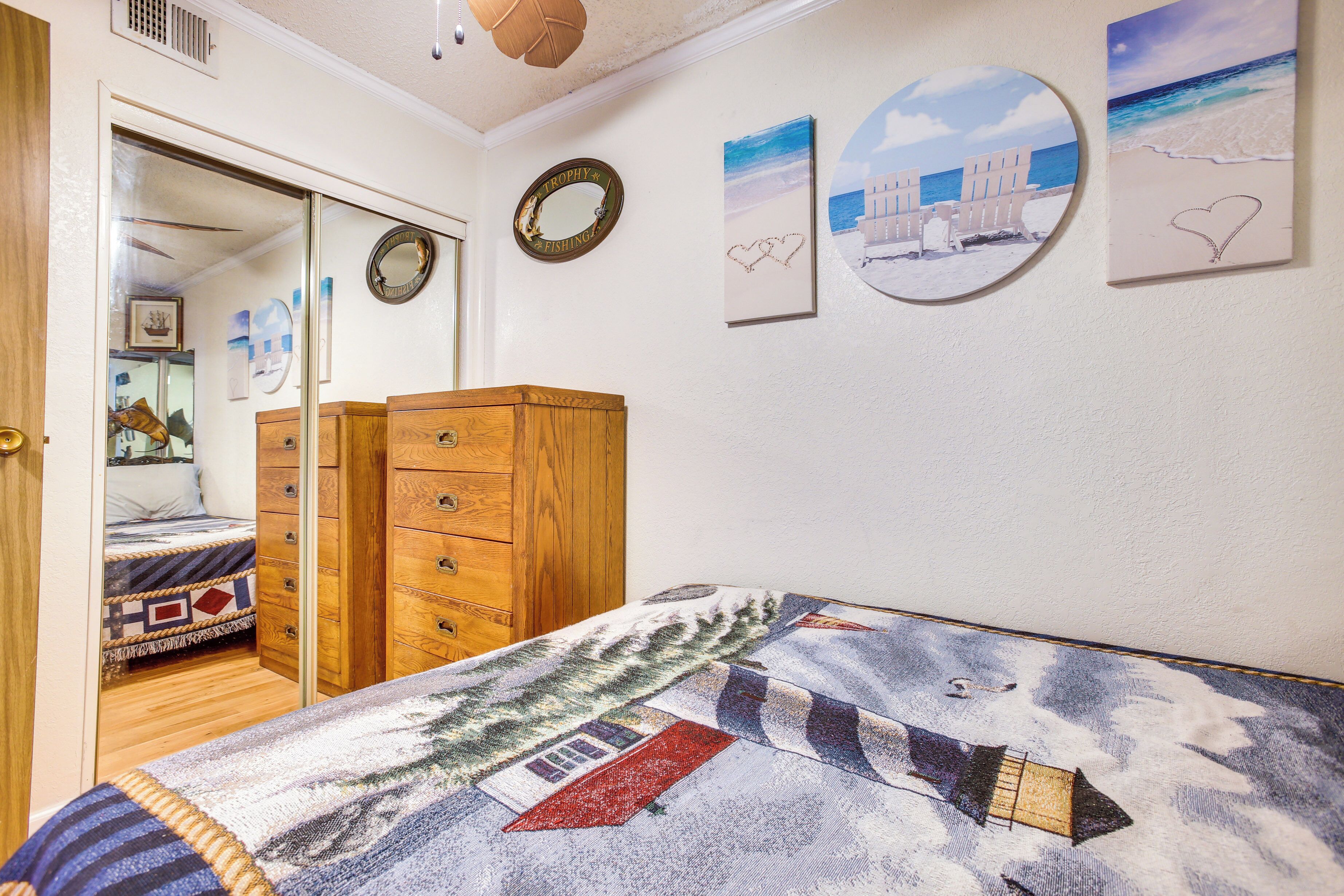 A bedroom with a bed, wooden wardrobe, and a door leading to another room.