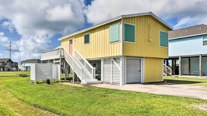 Ein zweistöckiges Gebäude mit einer Treppe zum Obergeschoss, einer Veranda und einer Garage.