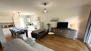 En moderne lejlighed med spiseområde, køkken, opholdsstue og et stort vindue.