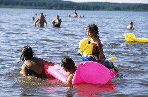 Un lac où des gens nagent et flottent sur des jeux gonflables.
