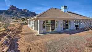 A house with a large patio, stone wall, and a view of a mountain. - Grand Junction Mountain Escape w/ Grill! (Grand Junction)
