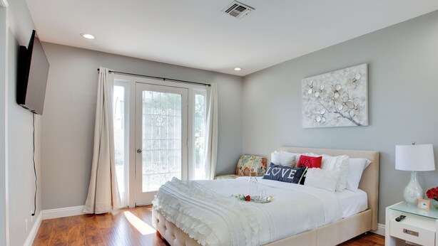 A bedroom with a large bed, a TV mounted on the wall, and a window with curtains. - Las Vegas Retreat w/ Yard < 5 Mi to Strip! (Las Vegas)
