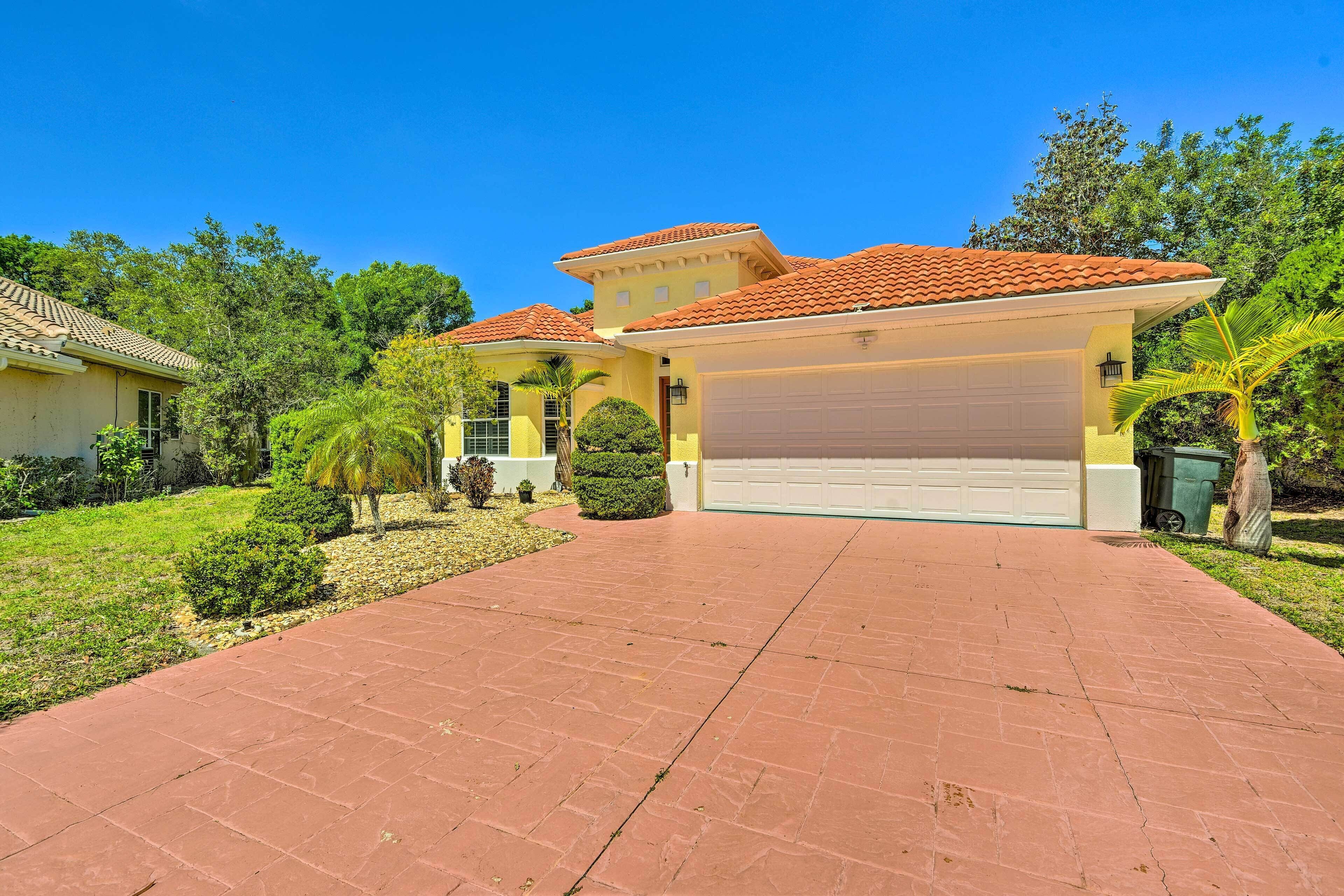 A residential house with a red-tiled roof, a garage, and a paved driveway.