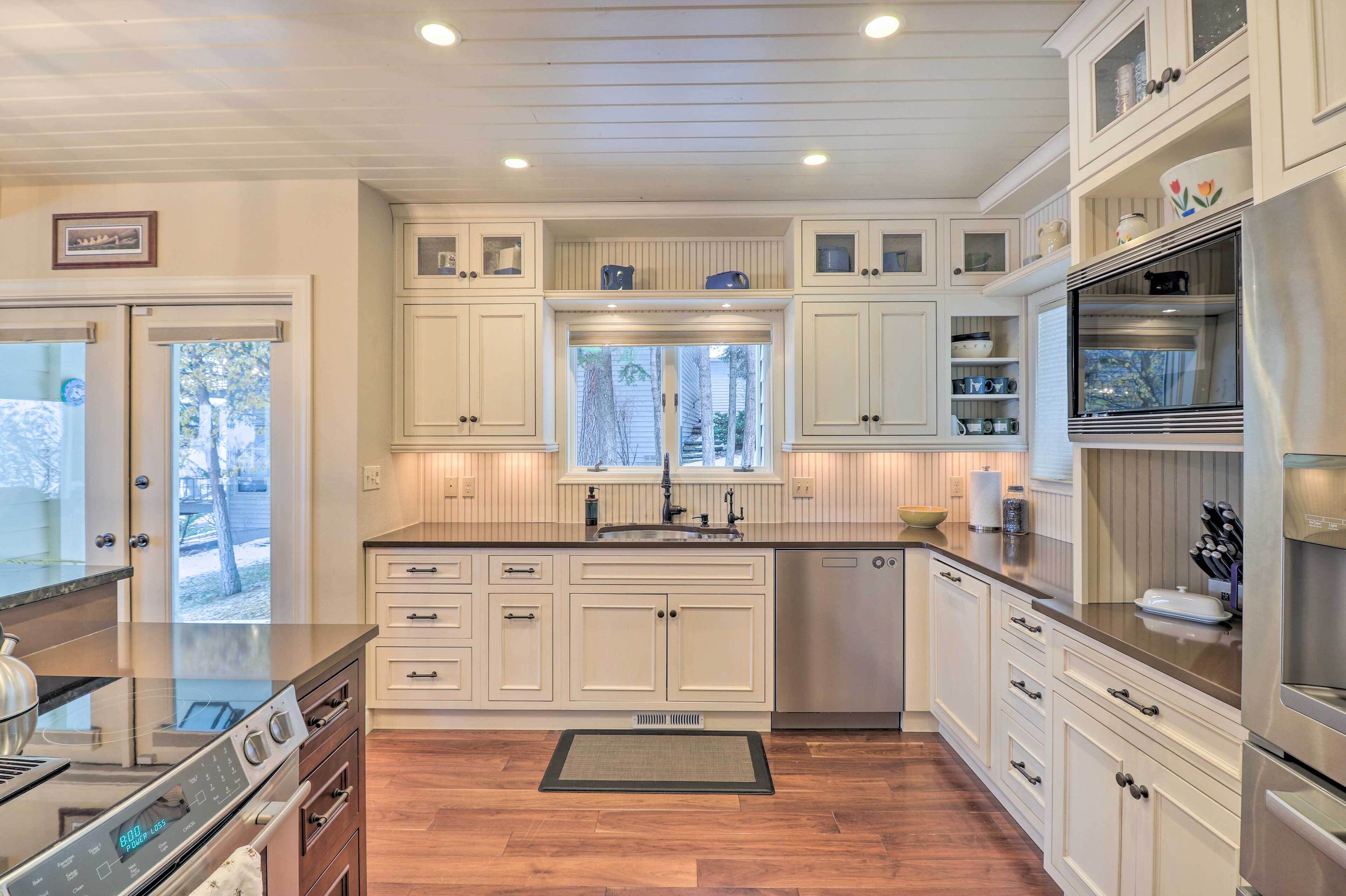 A kitchen with white cabinetry, a stainless steel stove, and a window above the sink.