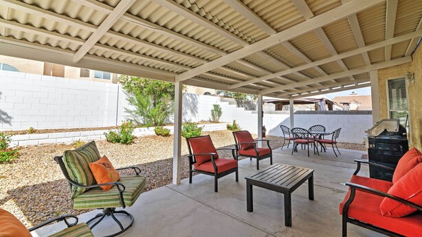 An outdoor patio with a covered area, seating arrangements, and a barbecue grill. - Spacious Las Vegas Home - Near Golfing & Hiking! (Las Vegas)