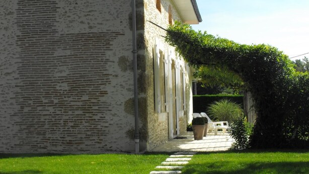 A stone building with a paved pathway leading to a door. - Lajenet - Benquet - Gîte (BENQUET)