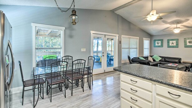 A kitchen with a dining table, chairs, a refrigerator, and a ceiling fan. - Pensacola Home - 2 Blocks From Boat Launch! (Pensacola)