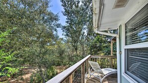 A wooden deck with a metal railing, overlooking a forested area. - Pensacola Home - 2 Blocks From Boat Launch! (Pensacola)