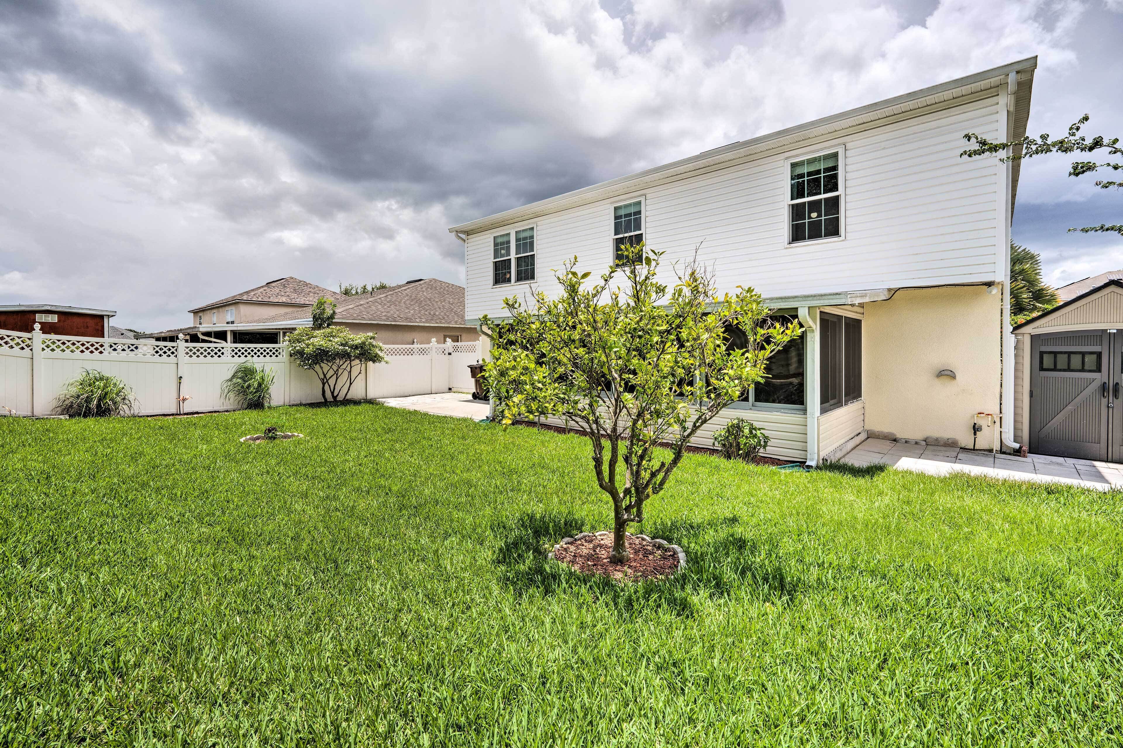 A two-story house with a well-maintained lawn and a small tree in the front yard.