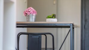 A metal table with a white top and a chair with a wooden seat and black metal frame. - Gîte Capérot - Eyres Moncube (EYRES MONCUBE)