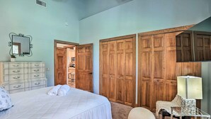 Une chambre à coucher comprenant un lit, une commode, un miroir, une lampe et des armoires en bois.