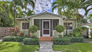 A two-story house with a front porch, a small garden, and palm trees. - < 9 Mi to Downtown Miami - Modern Getaway (Miami Springs)