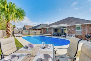 Ein Garten mit Swimmingpool, Sitzgelegenheiten im Freien und Grillplatz.