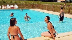 Een zwembad met mensen in het water en op het terras.