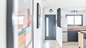 Eine moderne Küche mit einer dunkelblauen Tür, weißen Schränken und einer Holz Arbeitsplatte.