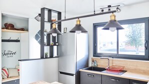 Eine moderne Küche mit integriertem Kühlschrank, einer Holzarbeitsplatte und einem Fenster mit Blick ins Freie.