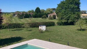 A rectangular swimming pool with a tiled deck, surrounded by a grassy lawn and a few trees. - A Noust - Cagnotte - Gîte (CAGNOTTE)
