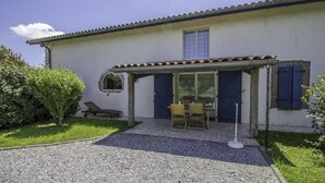 A house with a covered patio, a dining table, and chairs. - A Noust - Cagnotte - Gîte (CAGNOTTE)